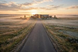 A road leading to a warm-lit building at dawn on the Alberta prairie, symbolizing the start of addiction treatment